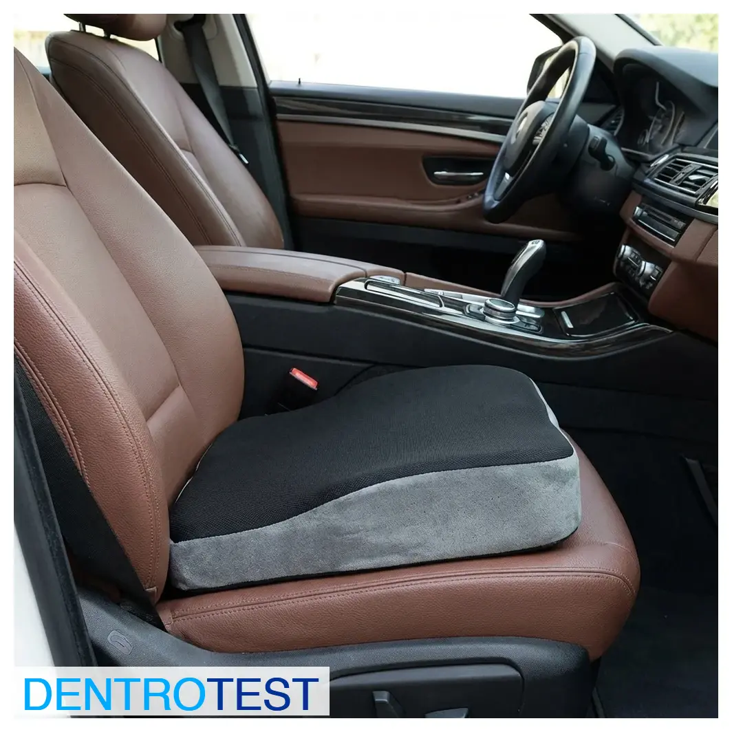 Is it advisable to drive while sitting on extra cushions or pillows placed on the seat?