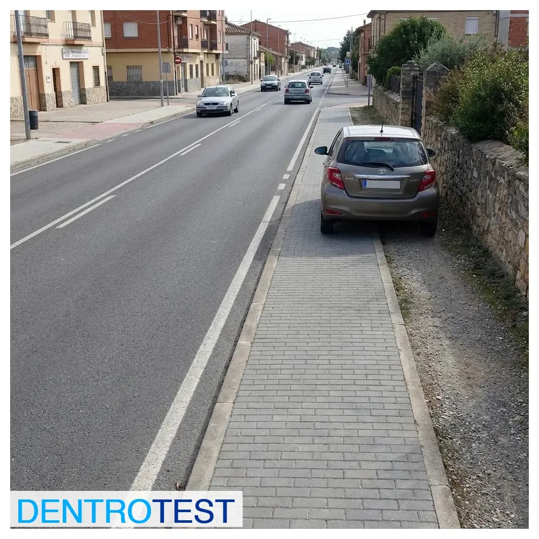 Is it allowed to park on the drivable shoulder of a road passing through a town (travesía)?