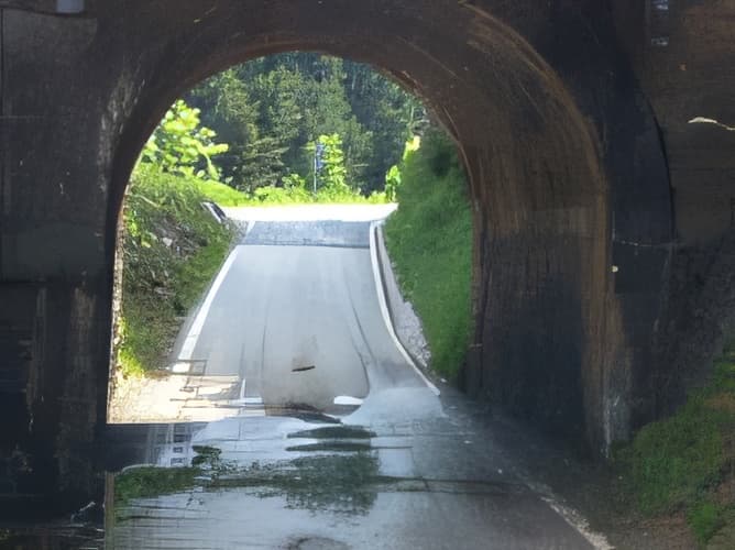 En ausencia de señalización y en un tramo de la vía en la que por su estrechez sea imposible el paso simultáneo de un turismo y una motocicleta, ¿quién pasará primero si ambos han llegado al mismo tiempo?