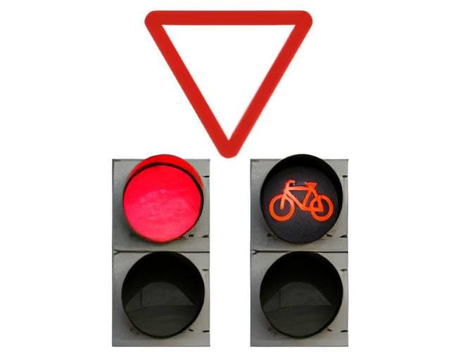 Llegamos a una intersección en la que encontramos la señalización de la imagen con un semáforo que presenta la silueta de un ciclo. ¿Qué debemos hacer?