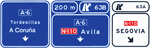 Signs over the carriageway on a motorway or dual carriageway. Two very close immediate exits towards a conventional road and continuing direction